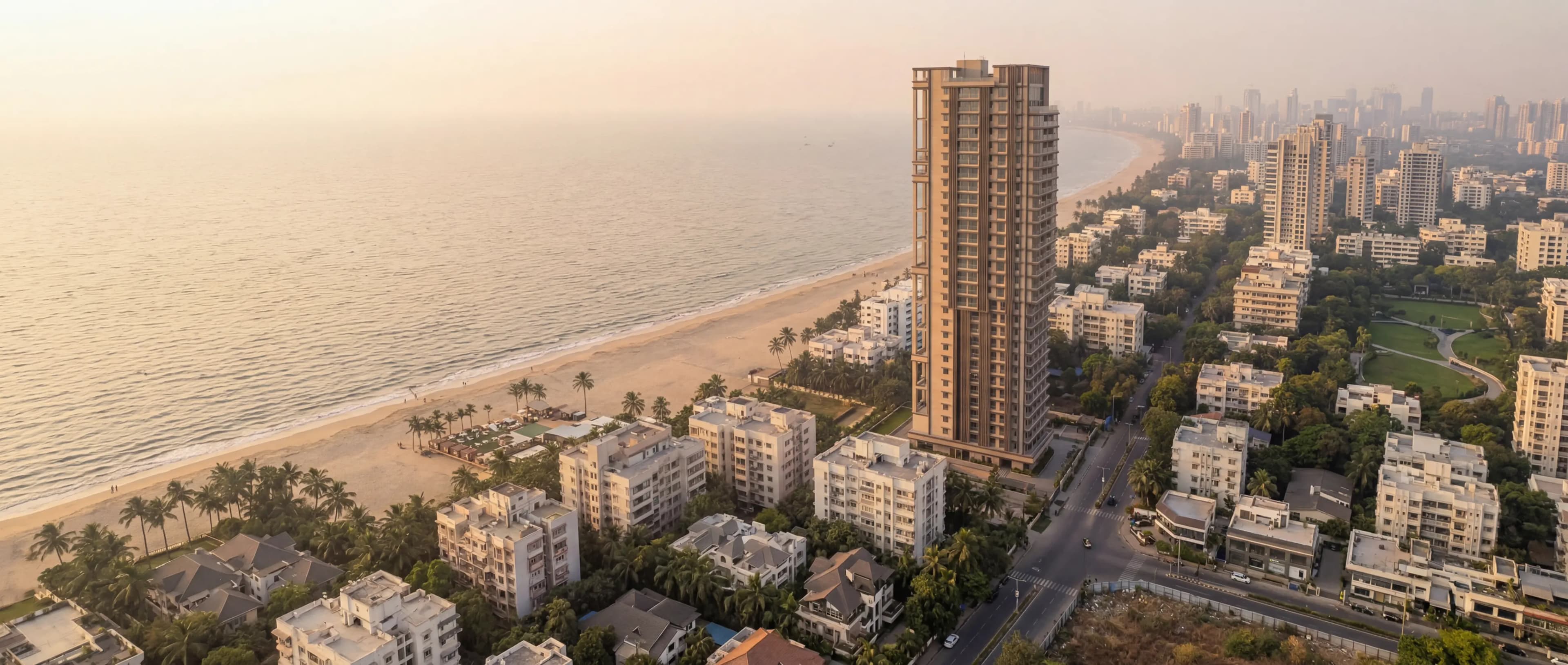 Aerial view of a Lotus tower rising over the Juhu shoreline at dusk.