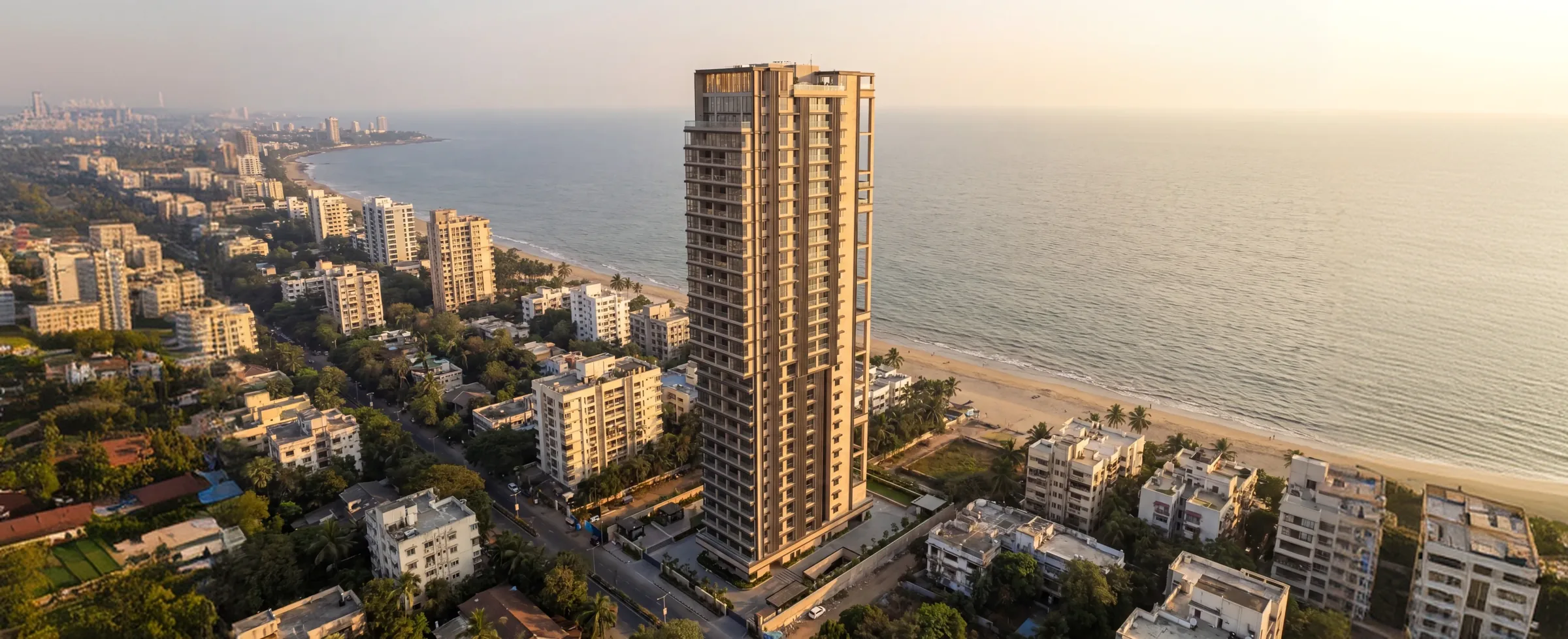 Amalfi: a slim Lotus tower standing over the Versova beachfront at sunset, the Arabian Sea beyond it.